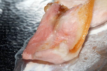 Sliced raw pork on a frying pan close-up.の写真素材