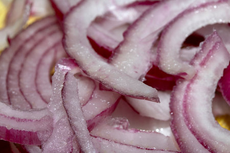 Close up of chopped and sliced red onion on wooden chopping boardの写真素材