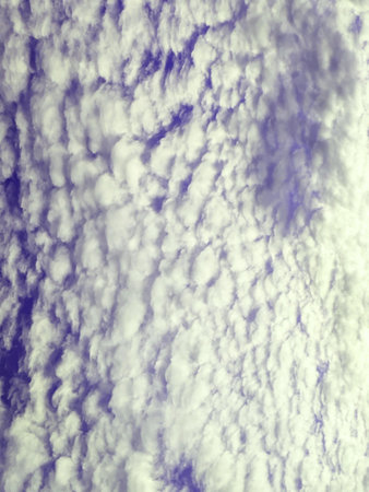 Abstract Thick White Fluffy Clouds on a Darker Blue Sky Backgroundの写真素材