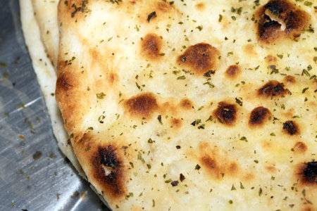 Close up of the surface of a fresh flatbread bread with herbs