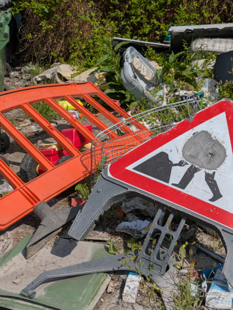Dumped abandoned roadwork signs and other items at the back of a car parkの写真素材