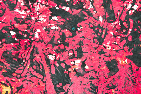 Thick red black and yellow paint in a scribbled abstract backgroundの写真素材