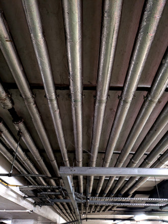 Industrial Metal Pipes on the Walls in a Car Park Buildingの写真素材