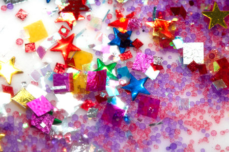 Close up of confetti tinsel glitter and shining stars on white backgroundの写真素材