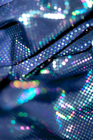 Holographic shiny spots and dots bokeh on fabric for a futuristic disco background