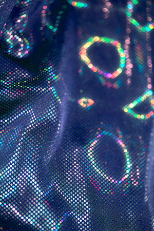 Holographic shiny spots and dots bokeh on fabric for a futuristic disco background