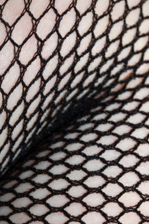 Close up of black fishnet tights on skin legs curves abstract backgroundの写真素材