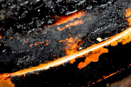Close up of heavy black rust on a brass base of a kitchen sauce pan abstract backgroundの写真素材