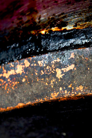 Close up of heavy black rust on a brass base of a kitchen sauce pan abstract backgroundの写真素材