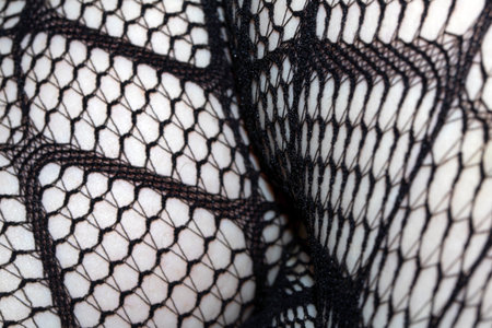 Close up of black fishnet tights on skin legs curves abstract backgroundの写真素材