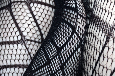 Close up of black fishnet tights on skin legs curves abstract backgroundの写真素材