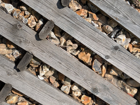 Old wooden railway tracks planks with stones and pebbles as a backgroundの写真素材