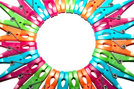 Colourful vibrant clothes pegs on a white background close up for laundry day