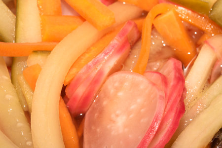 Close up of pickled vegetables including chopped carrot radish cucumber