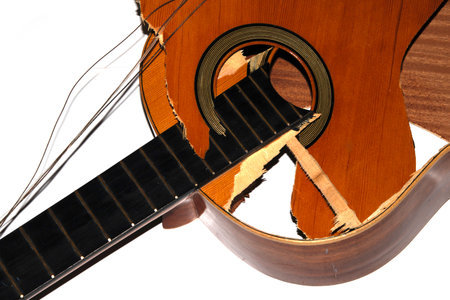 A broken smashed acoustic guitar music instrument on white backgroundの写真素材
