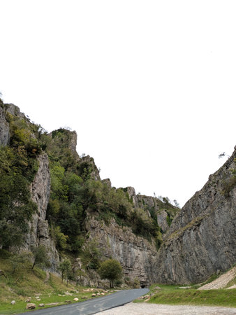 Tall cliff face jagged rocks and stone gorge mountains with clear sky in the UK landscape