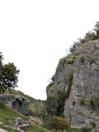 Tall cliff face jagged rocks and stone gorge mountains with clear sky in the UK landscape