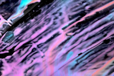 Mixed up wet acrylic colored paint on black plastic background abstract background style splatter