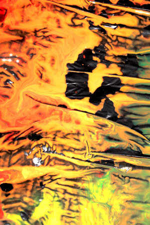Mixed up wet acrylic colored paint on black plastic background abstract background style splatter