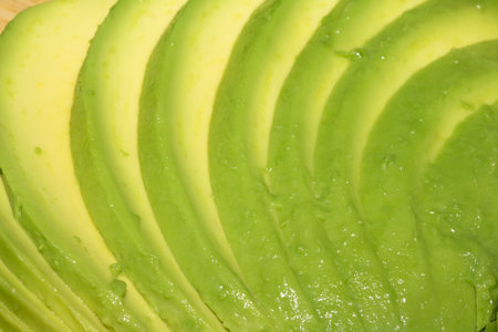 Close up of green fresh avocado sliced on chopping boardの写真素材