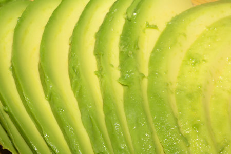 Close up of green fresh avocado sliced on chopping boardの写真素材