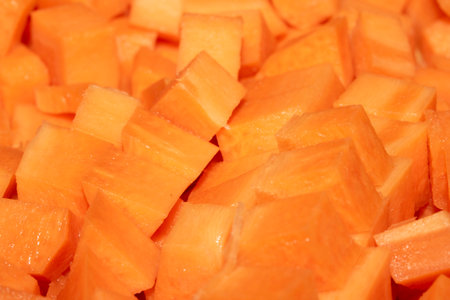Close up of cubed chopped and sliced carrots abstract background