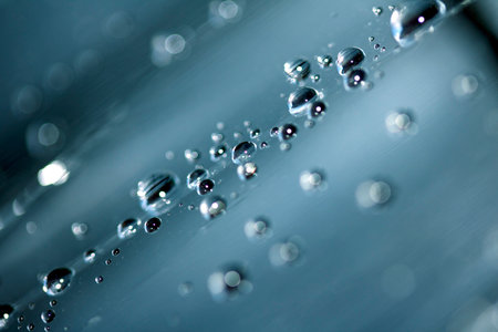 Close up of abstract floating bubbles water droplets condensation rain on a glass transparent bokeh backgroundの写真素材
