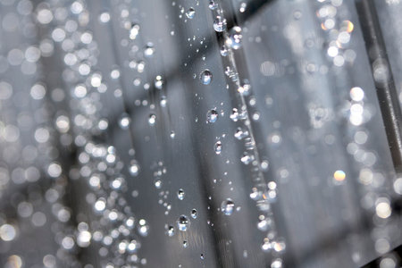 Close up of abstract floating bubbles water droplets condensation rain on a glass transparent bokeh backgroundの写真素材