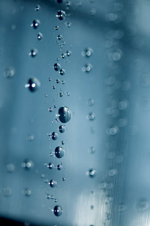 Close up of abstract floating bubbles water droplets condensation rain on a glass transparent bokeh...