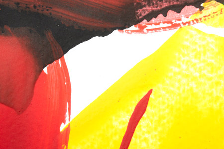 Vibrant thick red black and yellow acrylic paint splashes lines and swirls on a white backgroundの写真素材