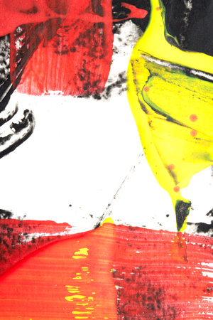 Vibrant thick red black and yellow acrylic paint splashes lines and swirls on a white backgroundの写真素材
