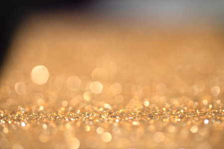 Gold shimmer glitter background with focus and bokehの写真素材