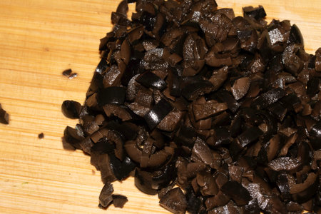 Close up of fresh chopped sliced black olives on chopping boardの写真素材