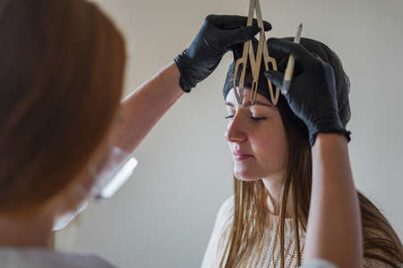 Permanent, Girl-master beautician makes eyebrow tattoo, women during permanent makeup, Permanent eye makeup, Beautician applies eye tattoo, Permanent procedure, Eyebrow correction procedure with permanent makeup, beauty salon, beautician's hands make eyebrow tattoo, permanent eyebrow makeup in a beauty salon , Cosmetology, Master beauticianの写真素材