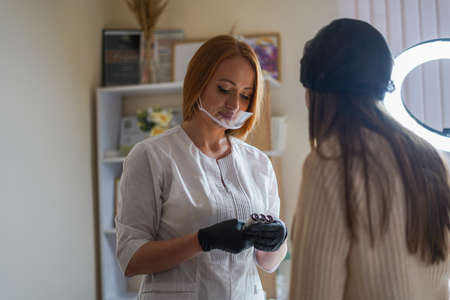 Girl-master beautician makes eyebrow tattooの写真素材