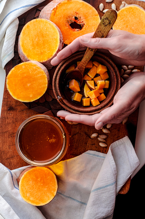 Hands take a plate of pumpkin and sweet honeyの写真素材