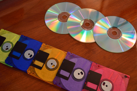 Floppy disks, and cd roms, showing progression of technology.