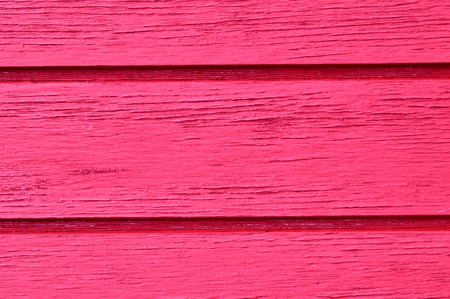Wood slats running horizontal, distressed, chipping paint job, in hot pink.の写真素材
