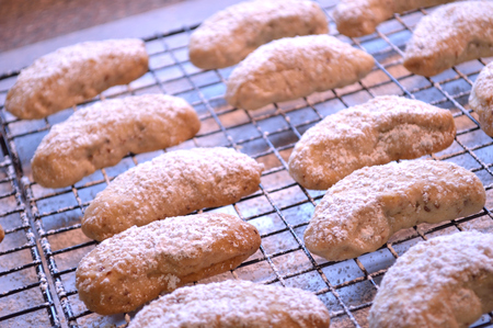 Crescent cookies, fresh out of the oven, and layed out on cooling racks to cool. Powdered sugar sprinkled on top.の写真素材
