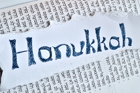 Hebrew word "hanukkah". Jewish holiday, festival of lights. Background is the hebrew text of the book of Isaiah in the tanach.の写真素材