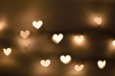 Bokeh lights, in the shape of little hearts, gold and sepiaの写真素材