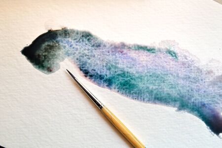Wet on wet technique example of a fluid watercolor wash on watercolor paper with paintbrushの写真素材