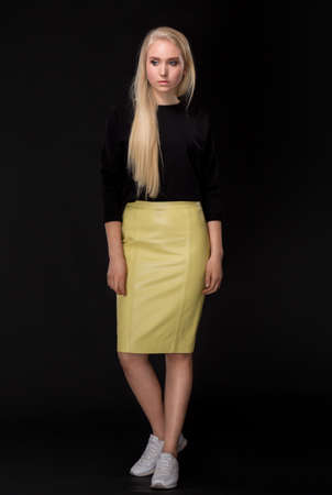 blonde woman with long hair posing on black backgroundの写真素材