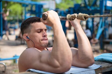 A hard-working guy is doing sports exercises in the parkの写真素材
