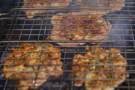 Fresh meat seasoned on the grill outdoorsの写真素材