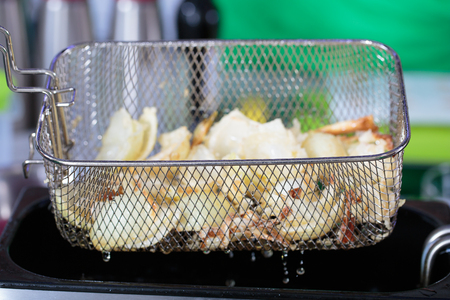 Deep fryer with food on restaurant kitchenの写真素材