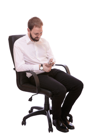 Fashionable man looking to mobile phone isolated on white backgroundの写真素材