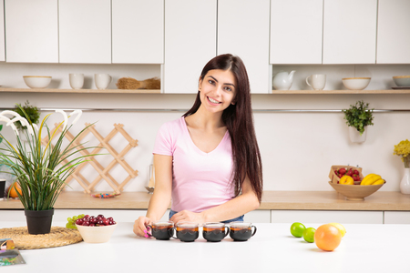 Attractive woman offering tea on the kitchenの写真素材