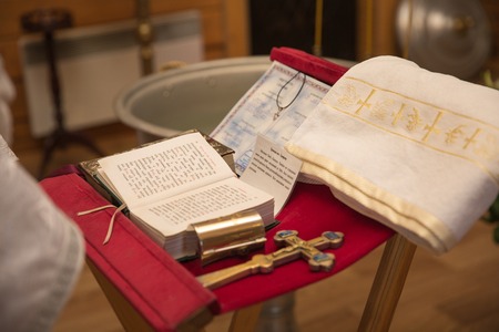 church utensil on an altar, glans, cross on the church altar,the Bible on the table, ceremony of water christening, priest holds a bible on a tableの写真素材