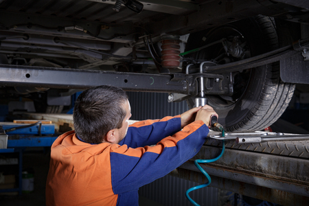 Mechanic Works on a Car. Repairs chassisの写真素材